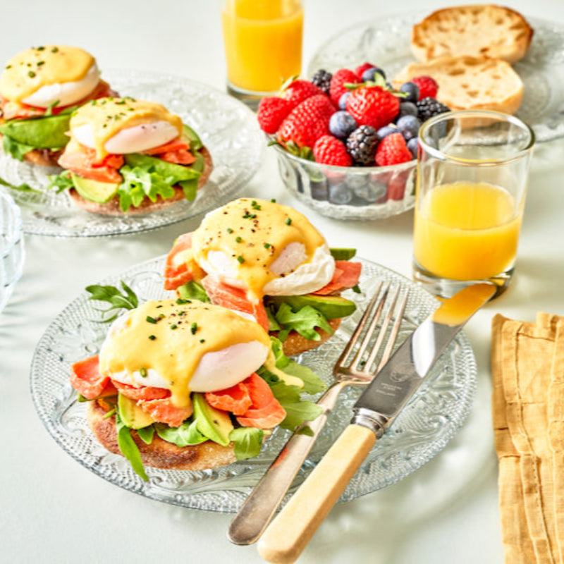 Breakfast table with Eggs Benedict and fresh berries.