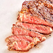 Sliced steak on a white paper background