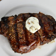 Steak with compound butter on a white plate
