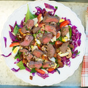 Salad with beef and vegetables on a plate with cutlery.