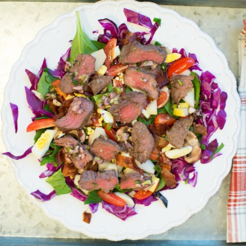 Salad with beef and vegetables on a plate with cutlery.
