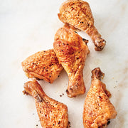 Roasted chicken drumsticks on a marble surface