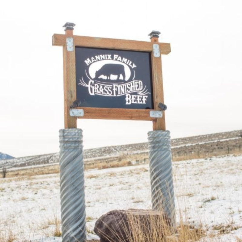 Sign for Mannix Family Grass Finished Beef in a snowy field.