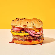 Hamburger with grilled cheese and onion on a yellow background